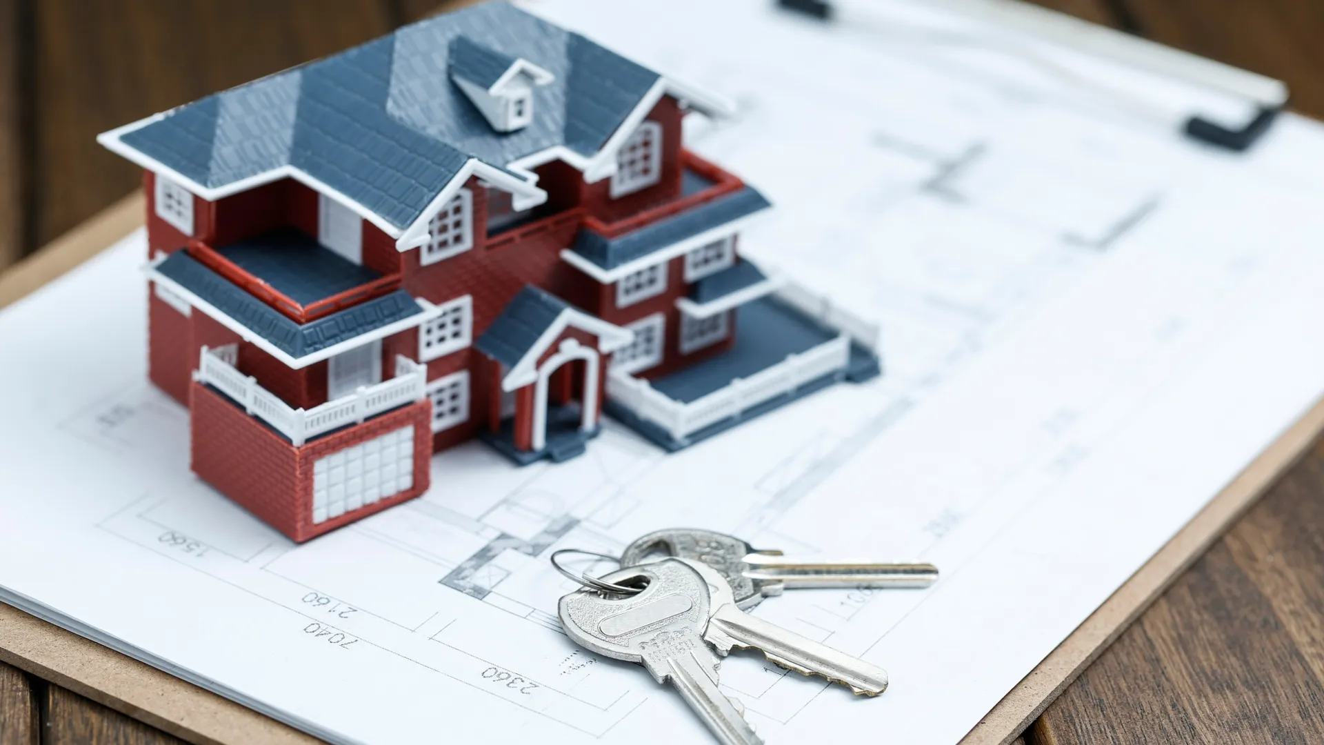 House model with keys on an architectural blueprint